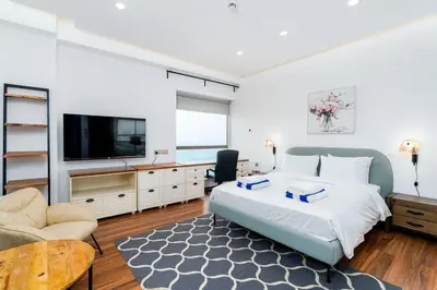 a bedroom with a bed and a flat screen tv at JBR Bahar Beach Views 4 beds - DVH Holiday Homes in Dubai