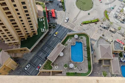 an overhead view of a building with a pool at JBR Bahar Beach Views 4 beds - DVH Holiday Homes in Dubai