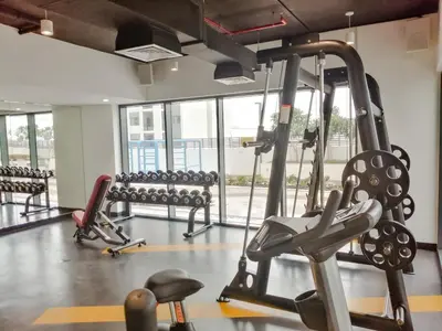 a gym with cardio equipment and benches in a room at Nasma Luxury Stays - Home-Style 2BR Apartment with a Balcony View in Dubai