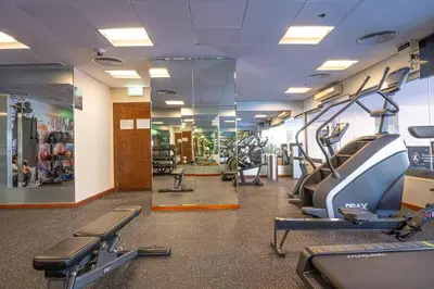 a gym with treadmills and ellipticals and mirrors at FIRST CLASS 2BR with Full Boulevard View in Dubai