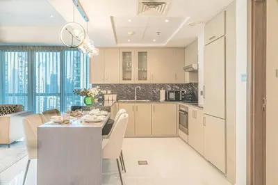 a kitchen and living room with a table and chairs at FIRST CLASS 2BR with Full Boulevard View in Dubai