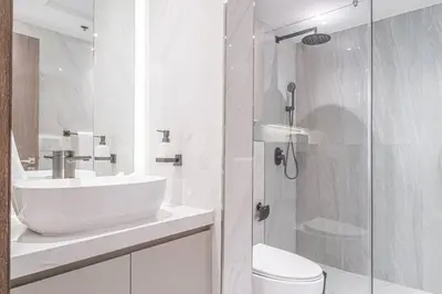 a white bathroom with a sink and a shower at FIRST CLASS 2BR with Full Boulevard View in Dubai