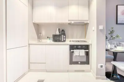 a kitchen with white cabinets and a microwave at Special Deal Scenic 1BR Close to Burj Khalifa by Deluxe Holiday Homes in Dubai