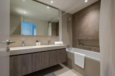 a bathroom with a sink and a tub and a mirror at 3BDR with Maid Room I Downtown I Burj Khaliva View in Dubai