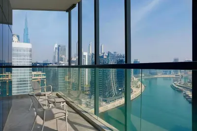 a balcony with two chairs and a view of the city at The First Collection Waterfront, Dubai, a Tribute Portfolio Hotel in Dubai