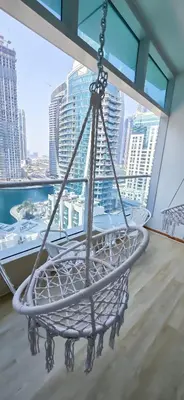 a swing in a balcony with a view of the city at Spacious Apartment Marina View in Dubai