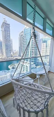 a hammock on a balcony with a view of the city at Spacious Apartment Marina View in Dubai