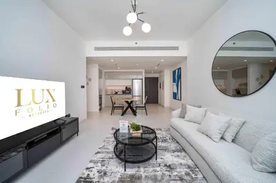 a living room with a couch and a tv at Marina Vista 1 Bed with Private Beach and Gorgeous Skyline in Dubai