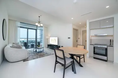 a kitchen and living room with a table and chairs at Marina Vista 1 Bed with Private Beach and Gorgeous Skyline in Dubai