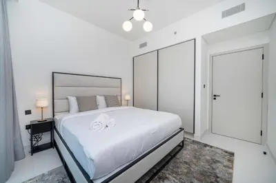 a bedroom with a white bed with two towels on it at Marina Vista 1 Bed with Private Beach and Gorgeous Skyline in Dubai