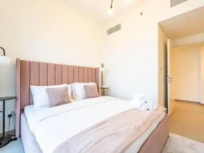 a bedroom with a large bed with a wooden headboard at Spectacular 2BR in Downtown Views II in Dubai