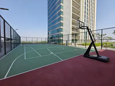 a tennis court in front of a tall building at Spectacular 2BR in Downtown Views II in Dubai