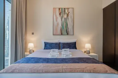 a bedroom with a large bed with two towels on it at Citihome - 1BR at Merano Tower by Damac in Dubai