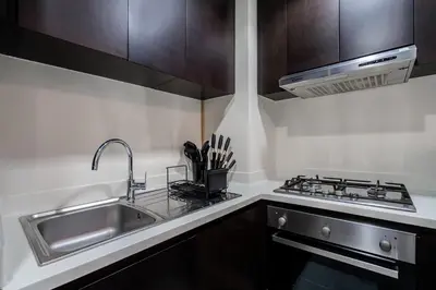 a kitchen with a sink and a stove at Citihome - 1BR at Merano Tower by Damac in Dubai