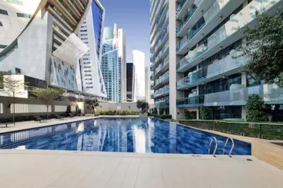 a swimming pool in a building with tall buildings at Citihome - 1BR at Merano Tower by Damac in Dubai