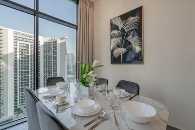 a dining room with a table and a large window at Citihome - 1BR at Merano Tower by Damac in Dubai