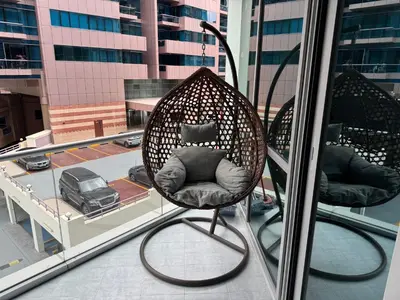 a wicker chair sitting on top of a balcony at Stylish Marina View Apartment in Dubai