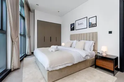 a bedroom with a large white bed and windows at Waves Holiday Homes - 15 Northside, Tower 1, Two Bedroom in Dubai