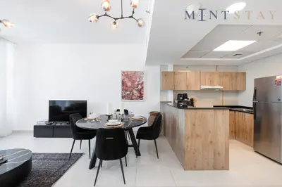 a kitchen and dining room with a table and a refrigerator at Continental Tower, Dubai Marina - Mint Stay in Dubai