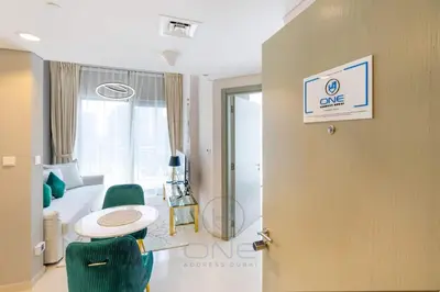 a room with a bed and a table and a door at 1BR Zada Tower l Two Balconies & City Views in Dubai