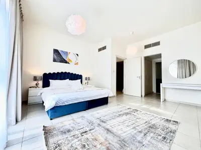 a white bedroom with a blue bed and a rug at Golf Facing 5Bedroom Villa in Novelia Village in Dubai