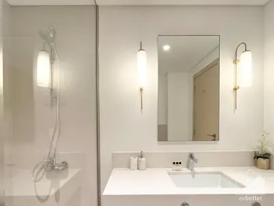 a white bathroom with a sink and a mirror at Luxurious stay Dubai Creek Balcony & View in Dubai