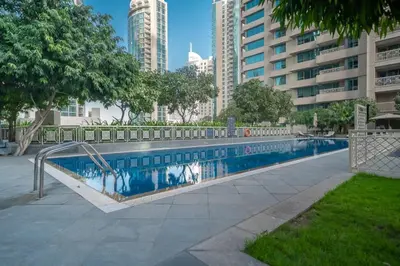 a swimming pool in a city with tall buildings at Bellavista - 1 BR - with Extra Room - Partial Fountain View in Dubai