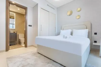 a bedroom with a large white bed and a bathroom at STAY BY LATINEM Luxury 2BR Holiday Home CV A814 near Burj Khalifa in Dubai
