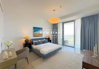 a bedroom with a king sized bed and a table at Harmonious 3BR in Stella Maris, Sea View, Marina in Dubai