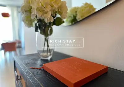 a book and a vase with flowers on a table at Harmonious 3BR in Stella Maris, Sea View, Marina in Dubai
