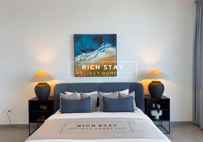a bedroom with a bed with two lamps and a painting at Harmonious 3BR in Stella Maris, Sea View, Marina in Dubai