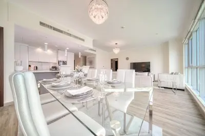 a dining room with a glass table and white chairs at Burj Residence 1, Downtown Dubai - Mint Stay in Dubai