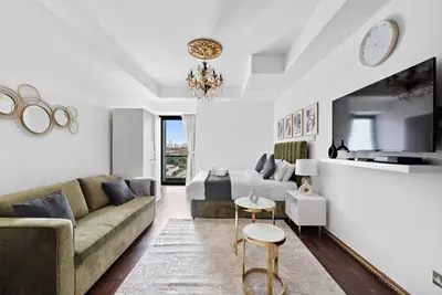 a living room with a couch and a table at StoneTree - Elegant Studio in Goldcrest View in Dubai