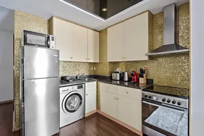 a kitchen with a refrigerator and a dishwasher at StoneTree - Elegant Studio in Goldcrest View in Dubai