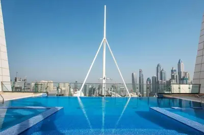 a swimming pool on top of a building with a city skyline at StoneTree - Elegant Studio in Goldcrest View in Dubai