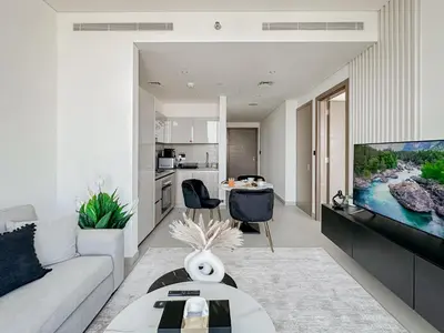 a living room with a couch and a tv at Trophy - Cozy Elegant Suites in Dubai