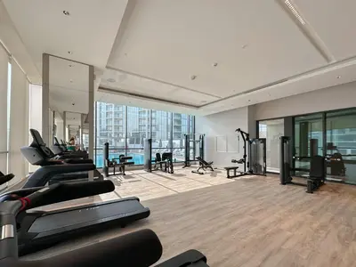 a gym with treadmills and exercise equipment in a building at Trophy - Cozy Elegant Suites in Dubai