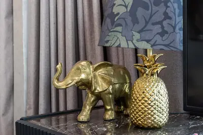 a gold elephant and a vase on a table at High floor Luxury 2BR - Dubai Marina Gate in Dubai