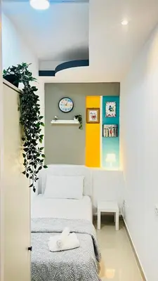 a bedroom with a white bed and a plant at Glamorous Partition Room in Barsha 1 Near Metro in Dubai
