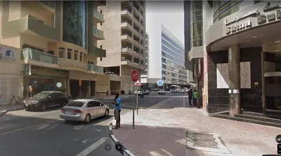 a person standing next to a stop sign on a city street at Glamorous Partition Room in Barsha 1 Near Metro in Dubai