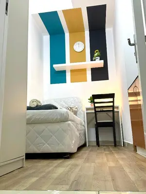 a bedroom with a bed and a clock on the wall at Charming Partition Room in Barsha Heights Near ICM in Dubai