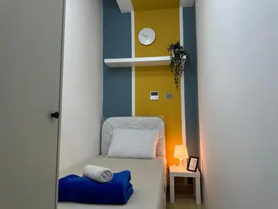 a room with a bed and a clock on a wall at Lovely Partition Room in Barsha 1 Near Metro in Dubai