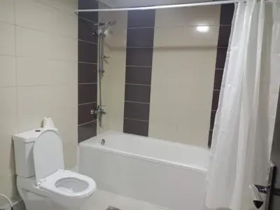 a bathroom with a toilet and a tub and a shower at Lovely Partition Room in Barsha 1 Near Metro in Dubai