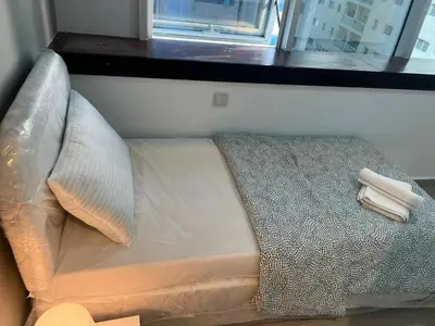 a small bed in a room with a window at Partition Room With Window Near MOE Metro in Dubai