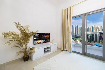 a living room with a tv and a large window at Luxury 1 Bedroom Full Marina View, Sleeps 6, 1 Min to Metro in Dubai