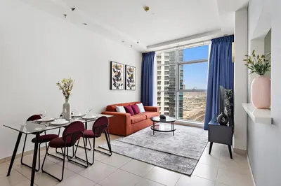 a living room with a couch and a table with chairs at StoneTree - Fully Furnished 1BR in Dubai Marina in Dubai