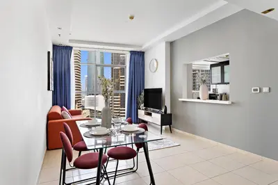 a living room with a table and chairs and a couch at StoneTree - Fully Furnished 1BR in Dubai Marina in Dubai