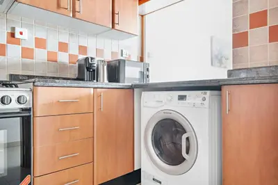 a kitchen with a washing machine in a kitchen at StoneTree - Furnished 1BR with Spacious Balcony in Dubai