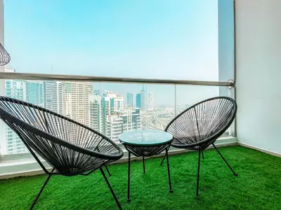 two chairs and a table on a balcony with a view at Cozy 1 BR in Dubai Marina in Dubai