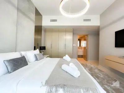 a bedroom with a large white bed with towels on it at Majestic 2Bedroom in Burj Royale Downtown in Dubai
